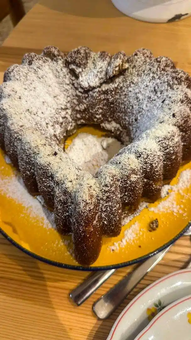 Herzförmiger, mit Puderzucker bestäubter Apfelkuchen auf einem Teller