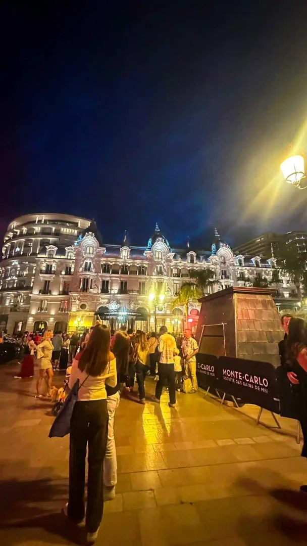 Hôtel de Paris in Monte-Carlo bei Nacht mit Passanten auf dem Platz