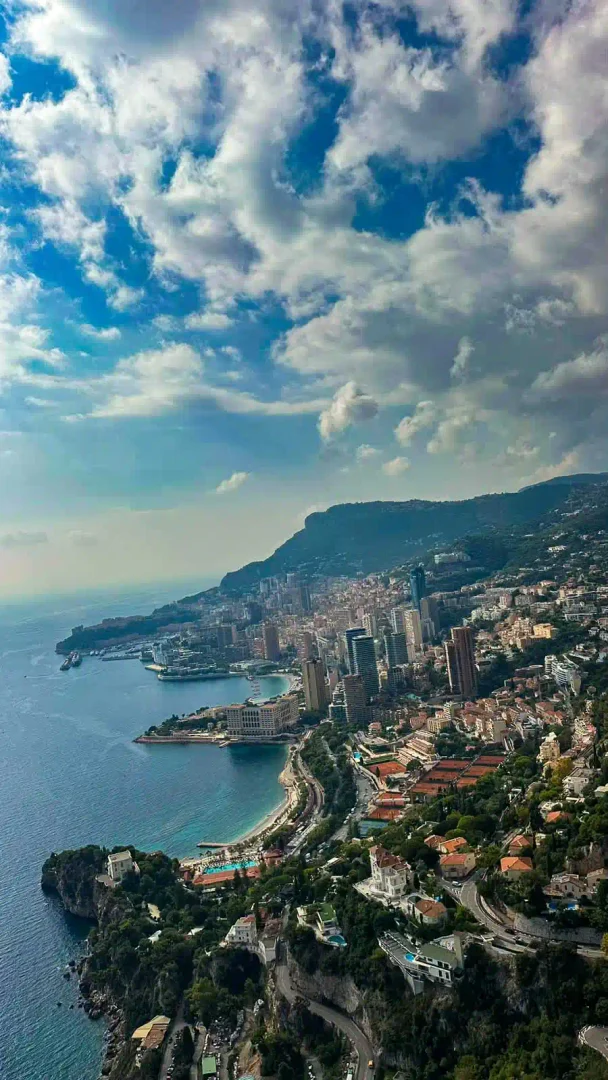 Hochformat-Luftbild der Küste von Monaco unter Quellwolken